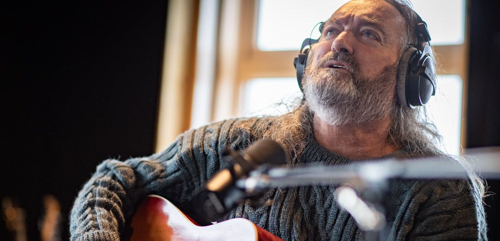 Martin playing the guitar looking into the distance